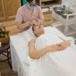 an aesthetician massaging client s face