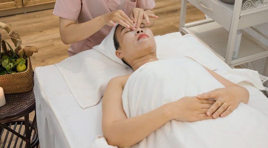an aesthetician massaging client s face