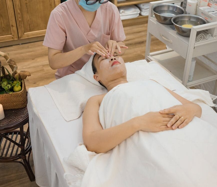 an aesthetician massaging client s face