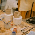 clay cups and paints on table