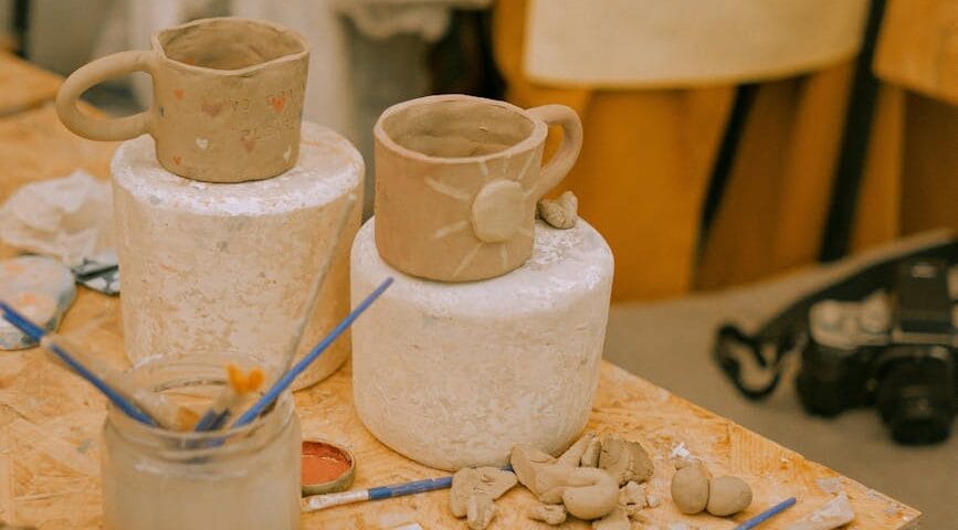 clay cups and paints on table