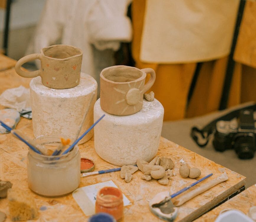 clay cups and paints on table