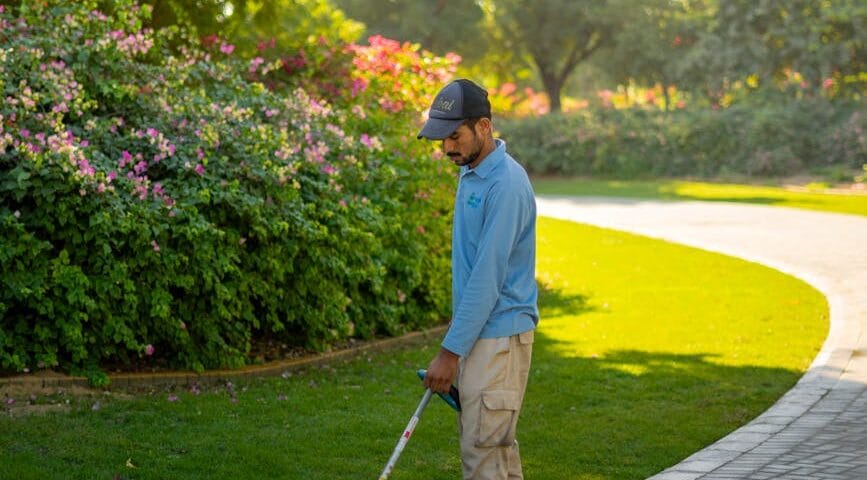 gardener maintaining park in dubai sunshine