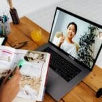 person teaching girl on laptop screen