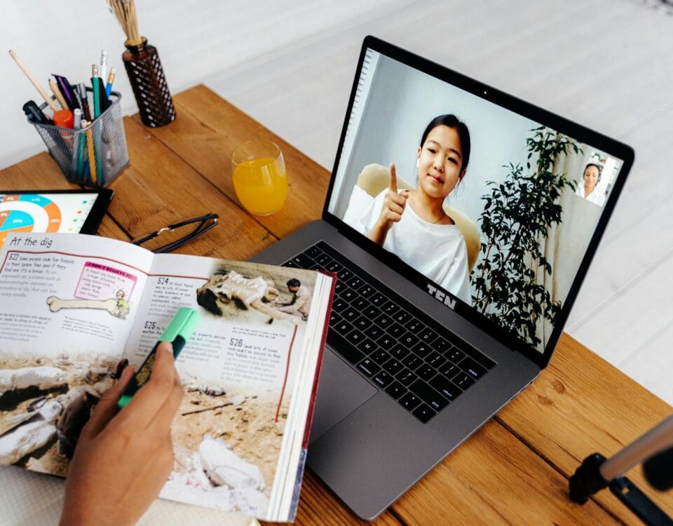 person teaching girl on laptop screen