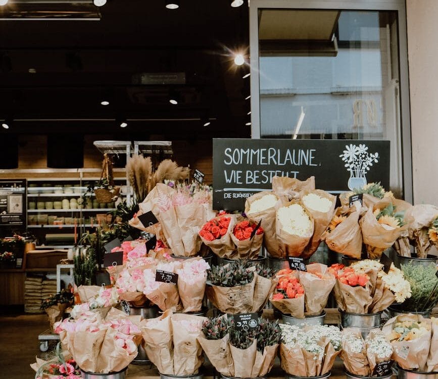 buckets of flowers displayed at a store
